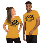 A black man and white woman wearing mustard color shirts that says Soca Mode in black print on the front.